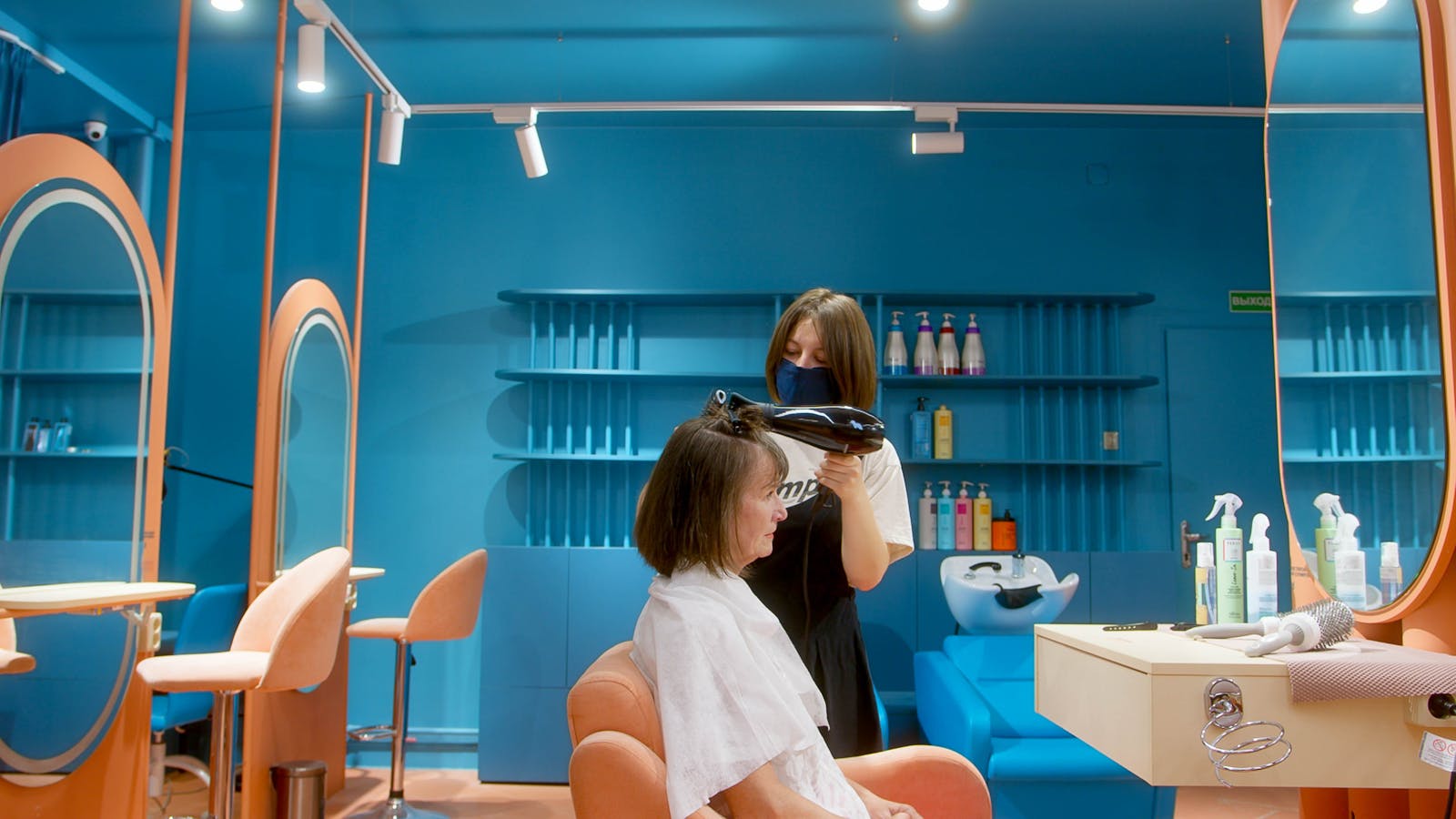 Hairstylist blow drying hair in a modern salon