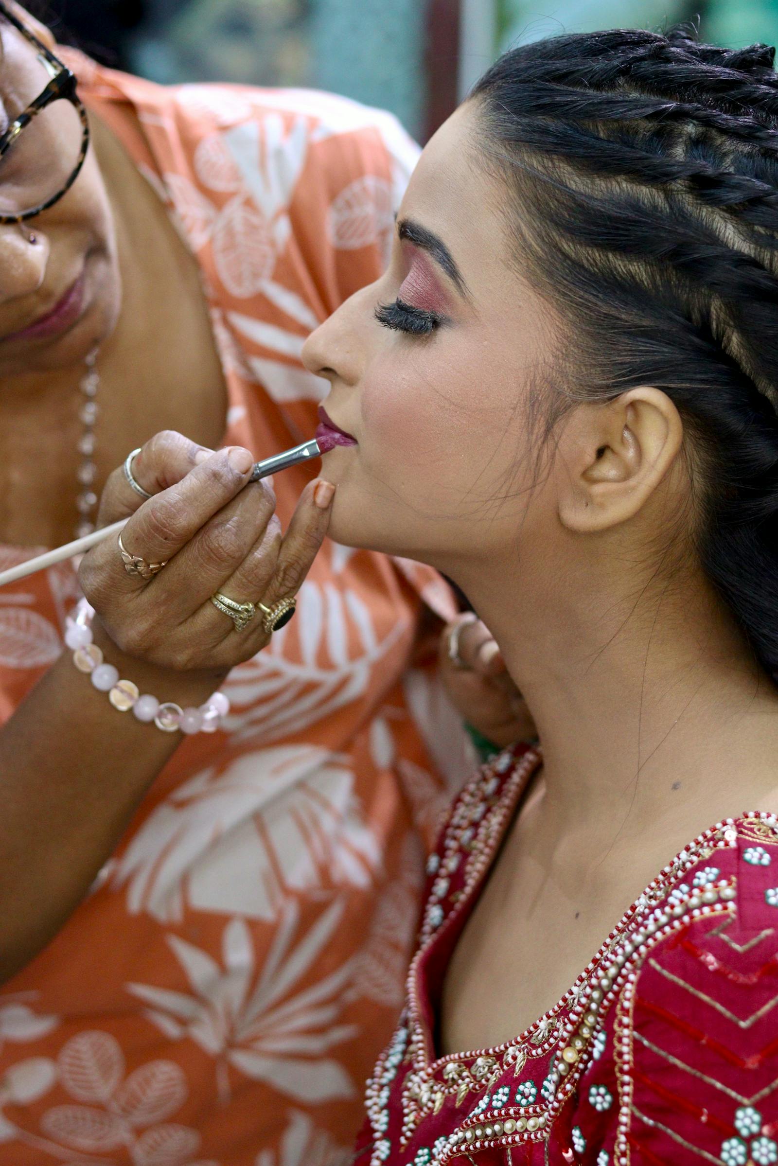 Bridal makeup artist applying a polished lip color